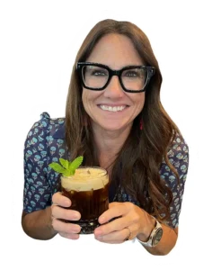Kim Bode smiles while holding a cocktail.