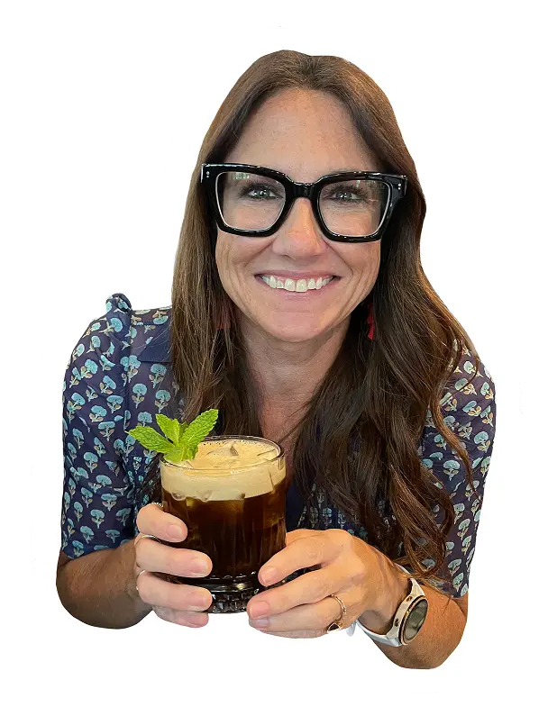 Kim Bode smiles while holding a cocktail.